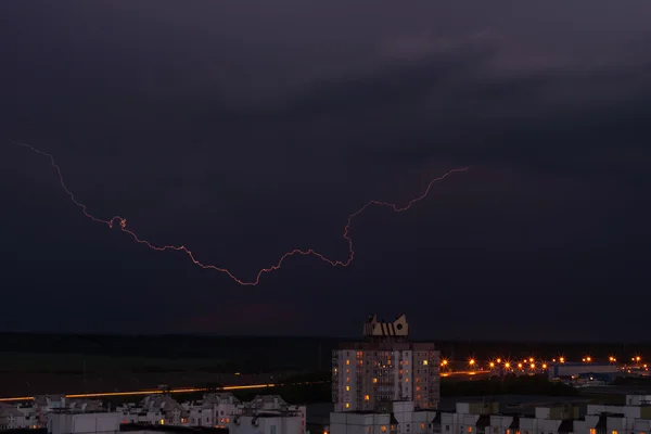 Lightning in the night sky over the city houses
