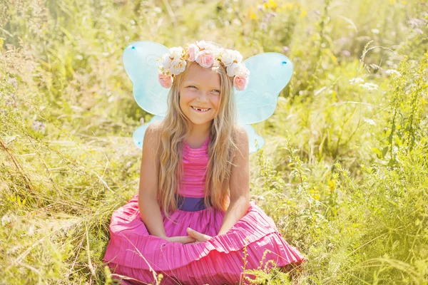 Little girl in a wreath and fairy wings