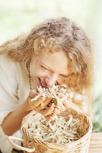 Woman smelling  dried herbs