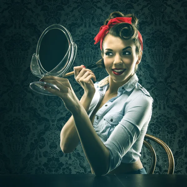 Woman holding mirror and makeup brush