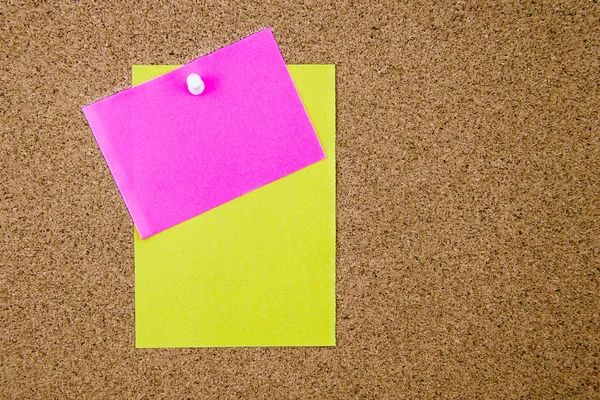 Blank paper notes pinned on cork board