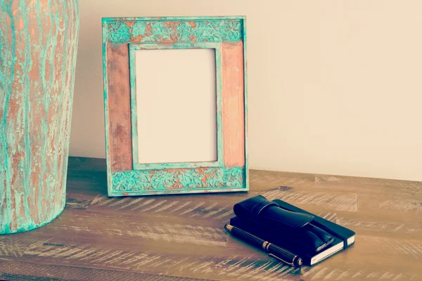 Vintage photo frame on wooden table over white wall background