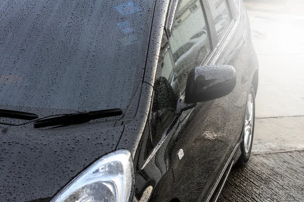 Raindrops on a car surface,Car wash, black car in automatic car wash