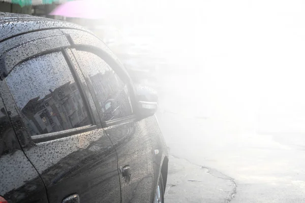 Raindrops on a car surface,Car wash, black car in automatic car wash