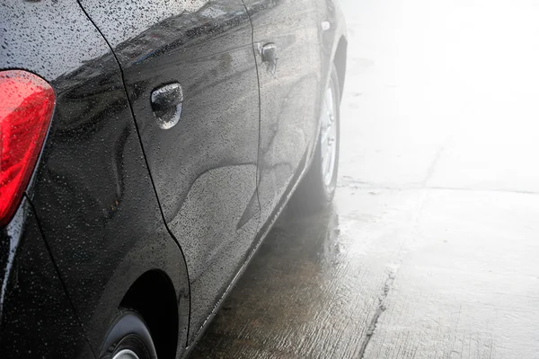 Raindrops on a car surface,Car wash, black car in automatic car wash