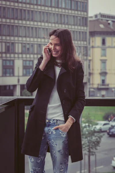 Pretty girl talking on phone in the city streets