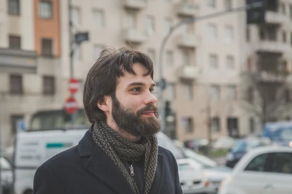 Young handsome bearded man posing in the city streets
