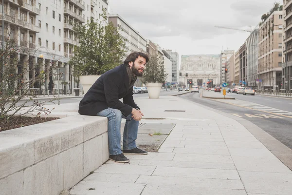 Young handsome bearded man posing in the city streets