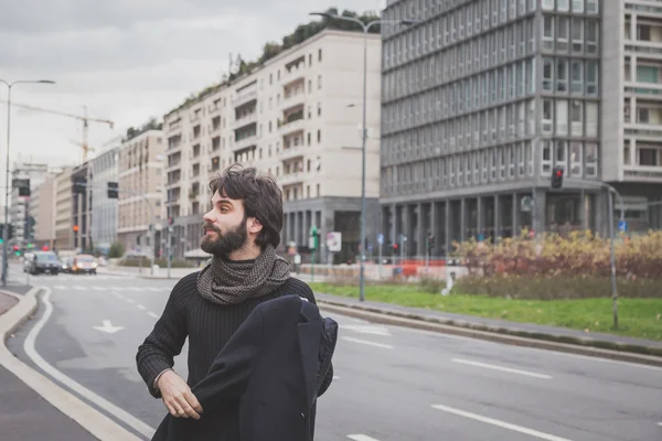 Young handsome bearded man posing in the city streets