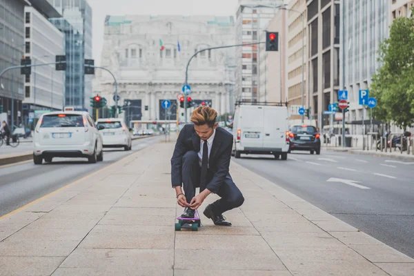 Young handsome Asian model posing on his skateboard