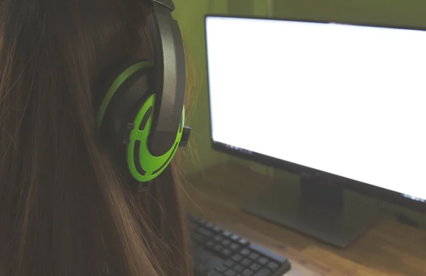Students working in computer class wearing headphones in college