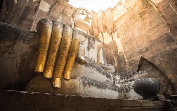 Ancient seated buddha staue in the temple ruins of sukhothai in