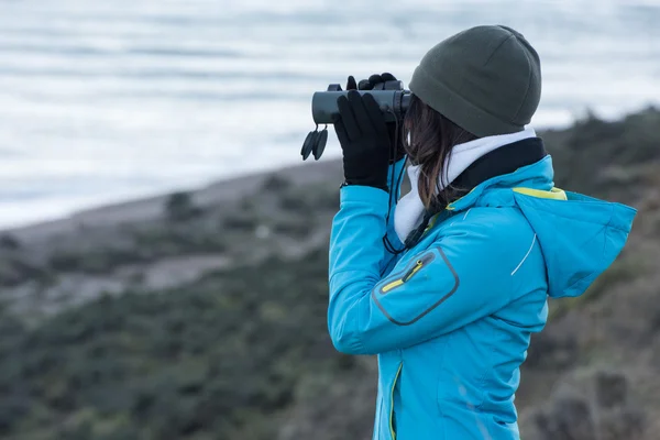 Girl looking sea with binoculars