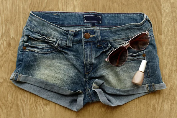 Women jeans shorts, nail polish and sunglasses