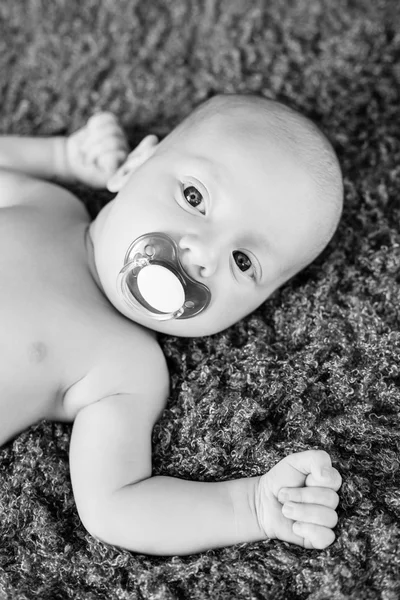 Cute baby with pacifier lying
