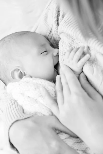 Mother breastfeeding the newborn smiling