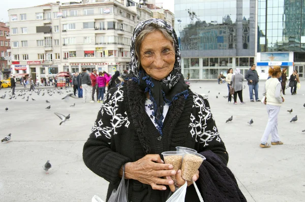 An old Turkish woman selling birds seeds