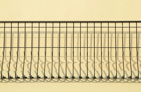 Decorative metal fence with shadow on the wall