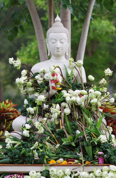 Buddhism worship with offering flowers and garland to buddha statue on Magha Puja, Asalha Puja and Visakha Puja Day in Thailand