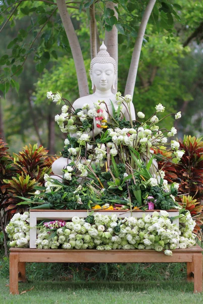 Buddhism worship with offering flowers and garland to buddha statue on Magha Puja, Asalha Puja and Visakha Puja Day in Thailand