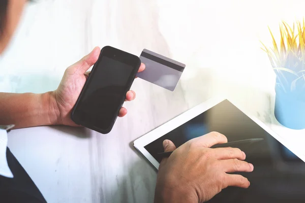 Businessman hands holding plastic credit card and using digital