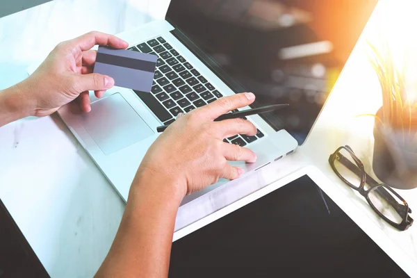 Businessman hands holding plastic credit card and using digital