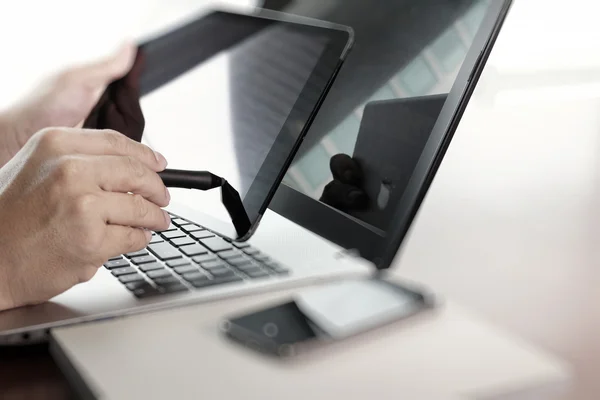 Businessman hand  working with tablet and laptop on wooden desk