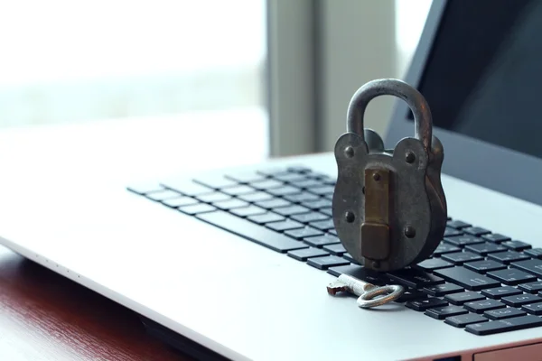 Internet security concept-old padlock and key on laptop computer
