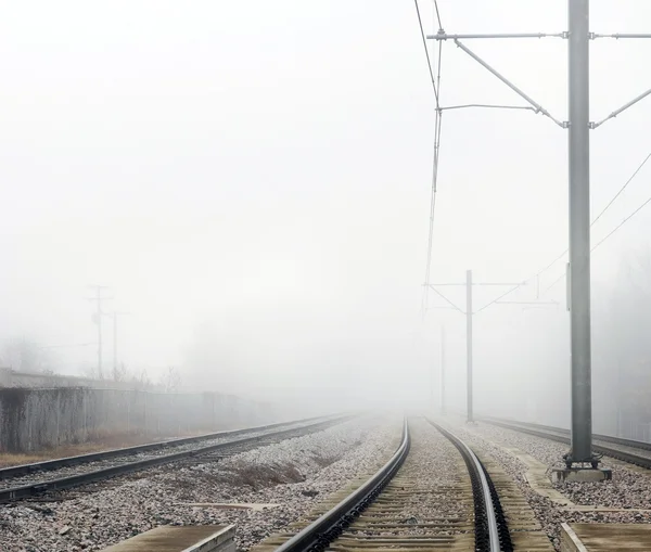 Train Tracks Disappearing Into Fog Concept