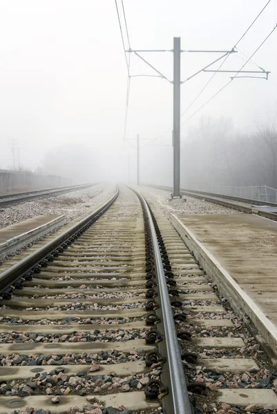 Train Tracks Disappearing Into Fog Concept