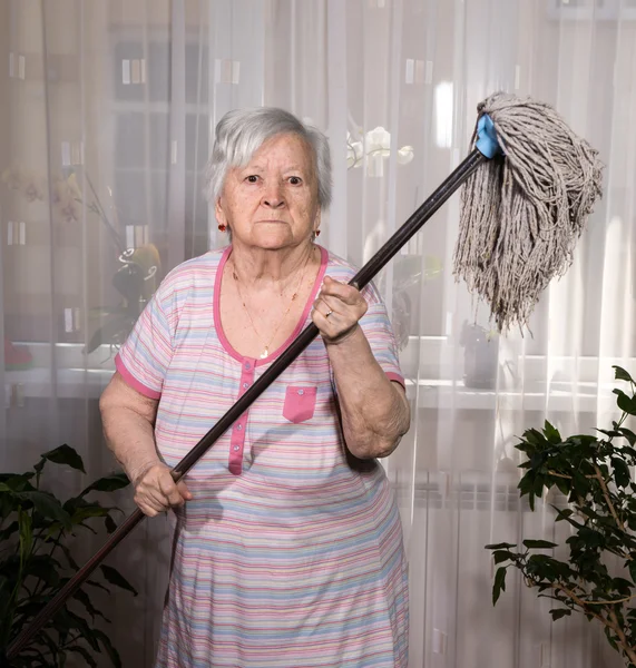 Old angry woman threatening with a mop