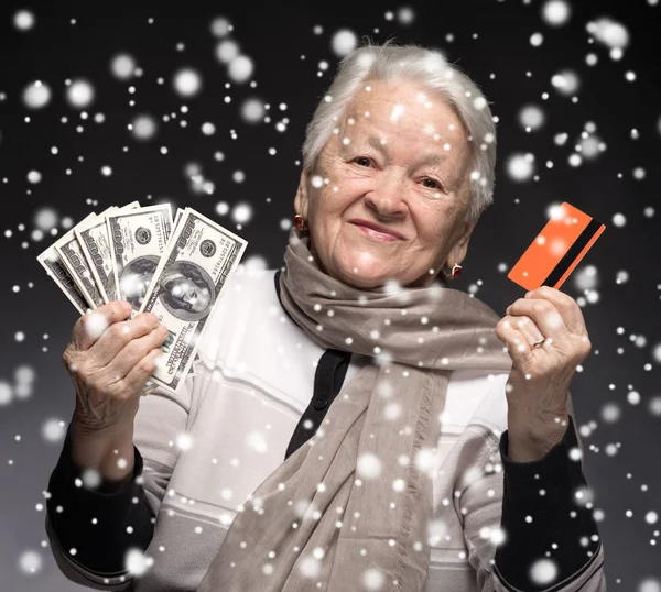 Old woman holding credit card and money