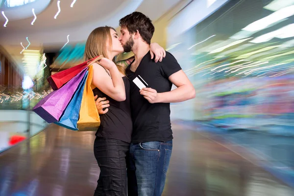 Happy kissing couple with shopping bags