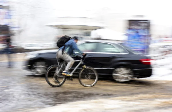 Man on bicycle in the city in a snowy day