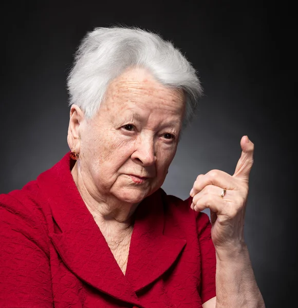 Portrait of old woman in angry gesture