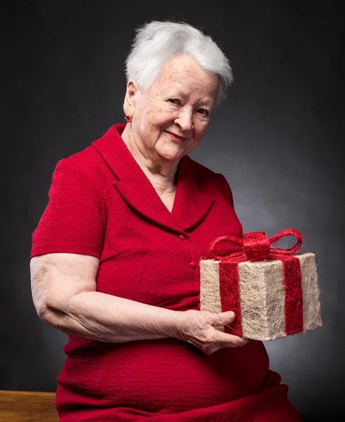 Smiling old woman with present box