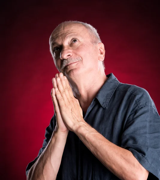 Religious senior man praying to god