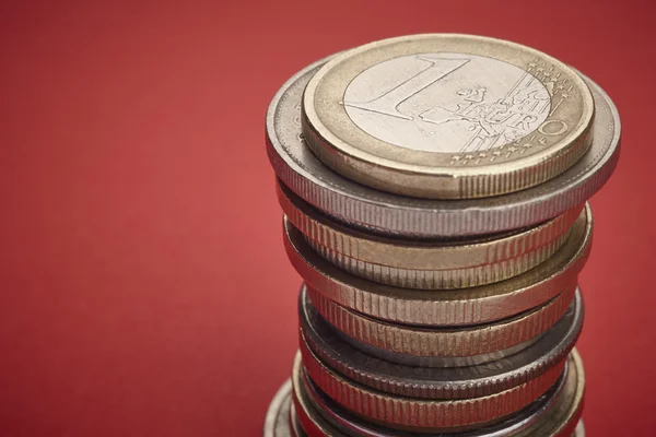 Different kinds on coins over a red background. Macro detail. Ho
