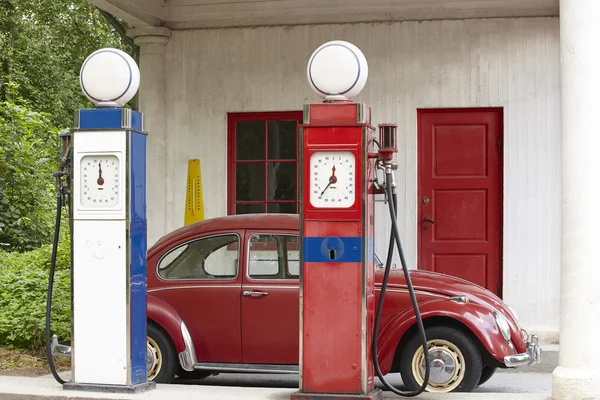 Old gas petrol station. Petrol pump and antique beetle car