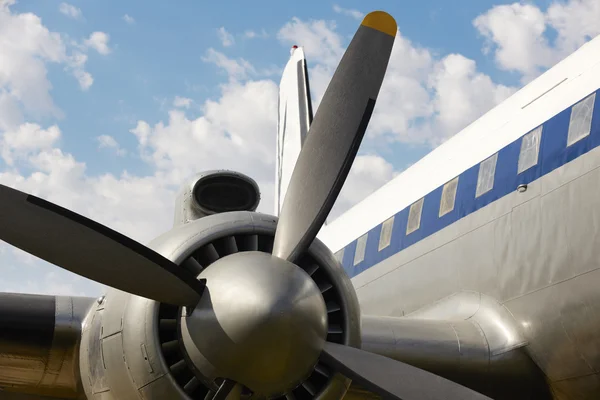 Old aircraft propeller and airframe with blue sky background