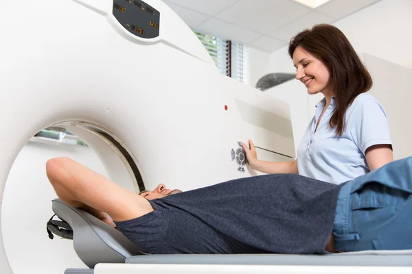 Medical technical assistant preparing scan of the spine with CT