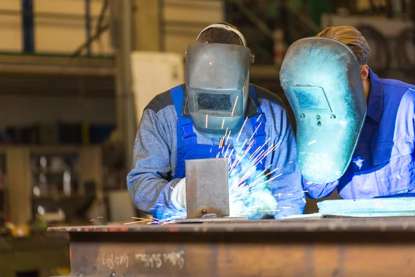 Two steel construction workers welding metal