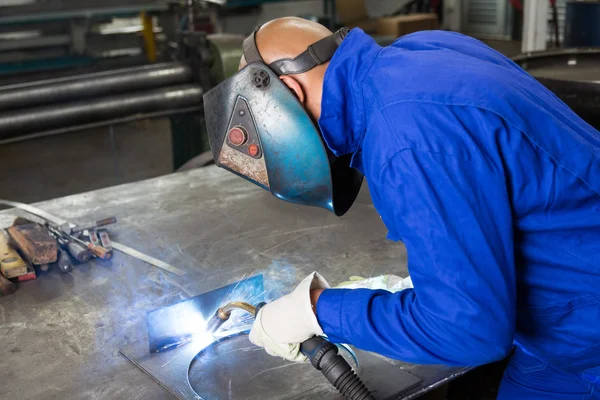 Professional welder welding metal pieces in steel construction