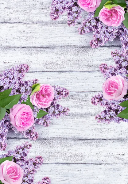 Lilac flowers with roses on background of shabby wooden planks