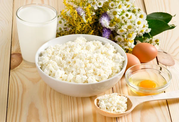 Cottage cheese with milk and eggs on the meadow flowers backgrou