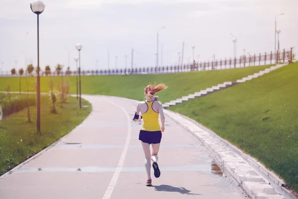 Young healthy lifestyle woman running at sunrise road.