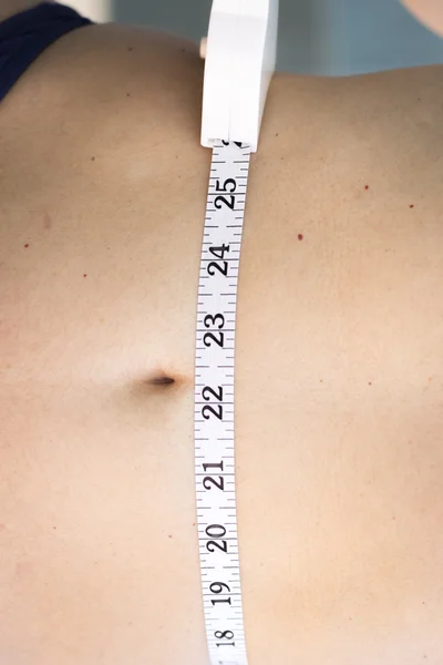 Woman measuring waist with tape