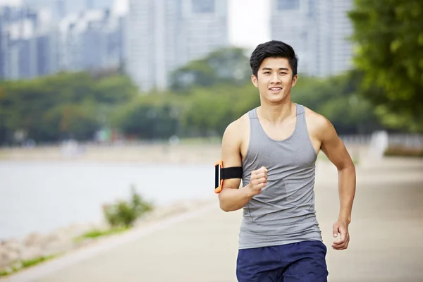 Young asian jogger running in park