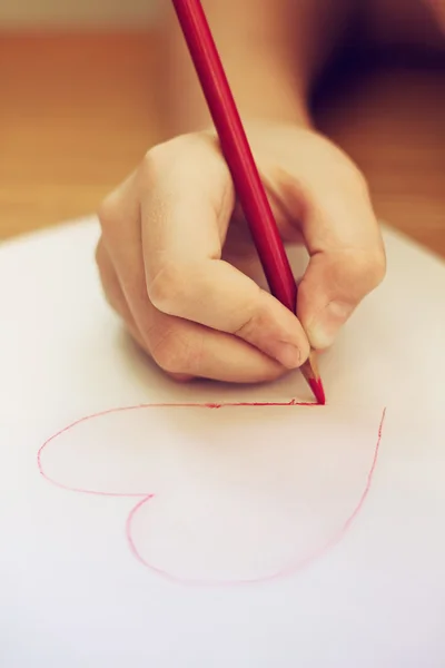 Child is drawing red heart