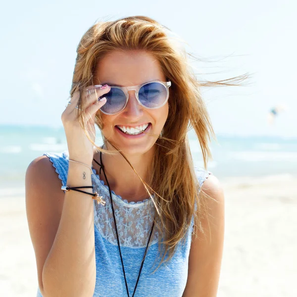 Blonde woman  in sunglasses on the beach